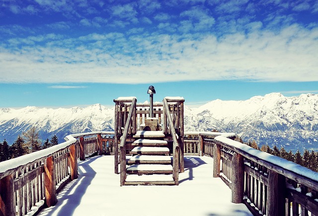 icy wooden deck with a mountain view