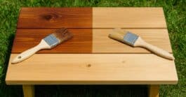 Wooden boards outdoors showing side-by-side results of oil-based stain with a rich glossy finish and water-based stain with a lighter matte look.